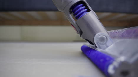 Dust-bunnies-and-vacuum-cleaner-on-dirty-floor-under-bed