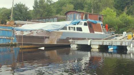 wooden motor cruiser being restored while moored to dock