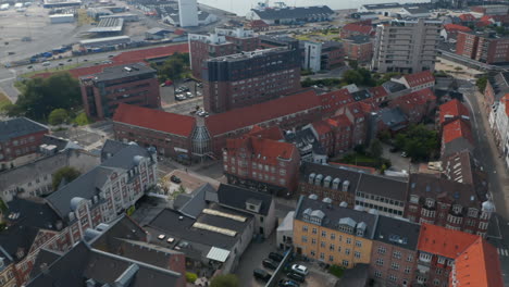 Vista-De-Arriba-Hacia-Abajo-De-Esbjerg,-Dinamarca,-Barrio-Con-Edificio-De-Ladrillo-Característico.-Vista-Aérea-Aérea-Que-Revela-El-Puerto,-Uno-De-Los-Más-Importantes-Para-El-Comercio-Y-Los-Negocios-En-El-Mar-Del-Norte