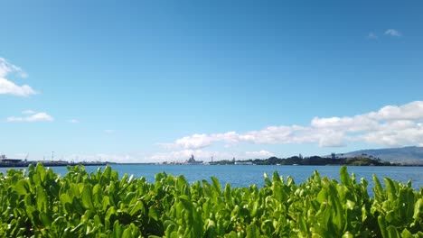 Static-wide-panning-shot-of-the-USS-Arizona-Memorial-at-Pearl-Harbor-with-foliage-in-the-background-on-the-island-of-O'ahu,-Hawaii