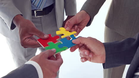 Business-colleagues-holding-pieces-of-puzzle