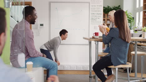 crazy happy asian business woman dancing doing victory dance in team meeting celebrating success achievement smacking booty