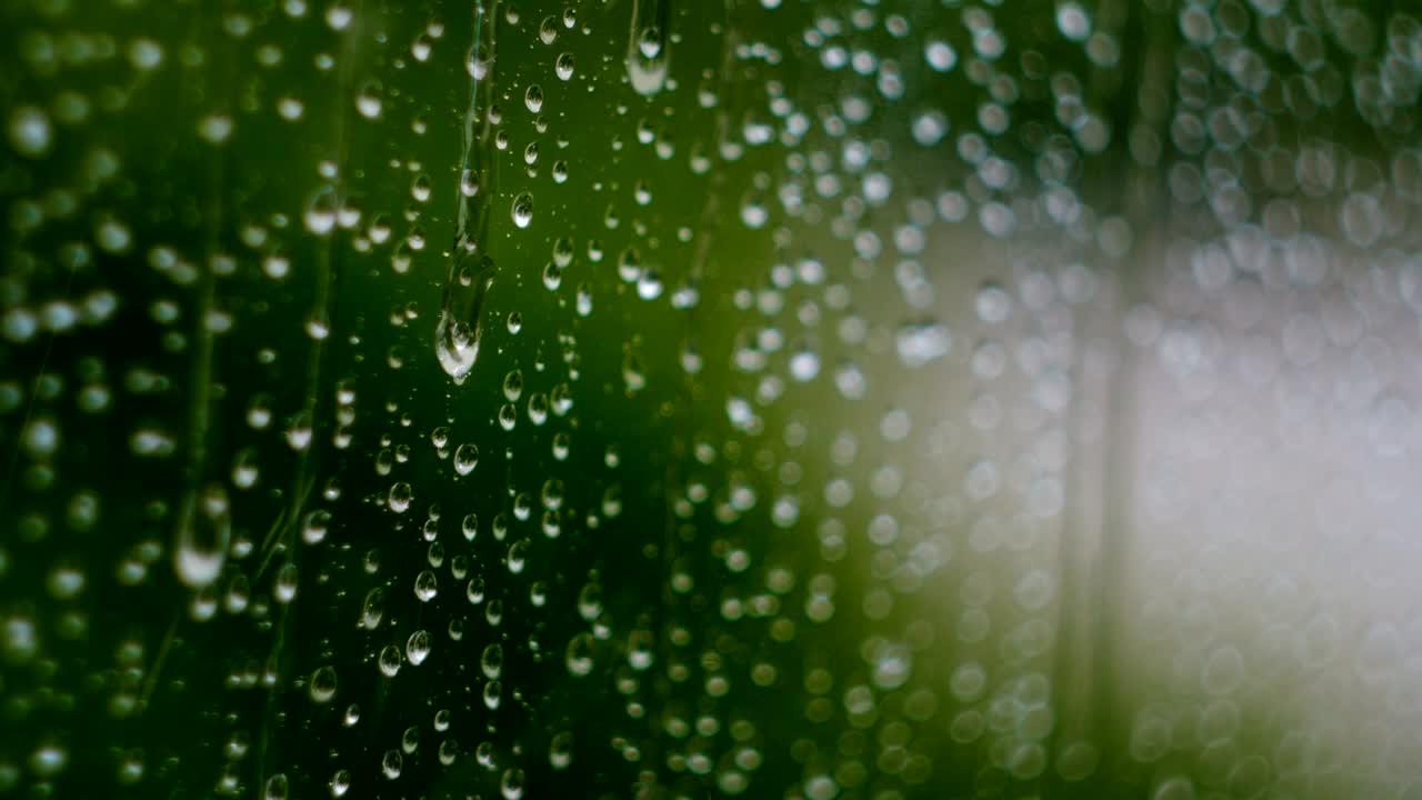 Raindrops running down a window pane