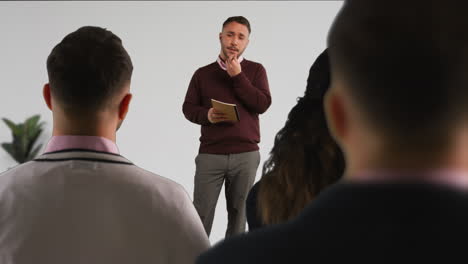 hombre de negocios o profesor universitario que da una presentación o una lección en la oficina o en el aula 1