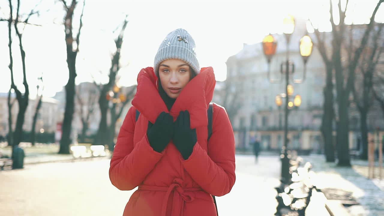 Woman in Red Coat and Beanie in a City Park