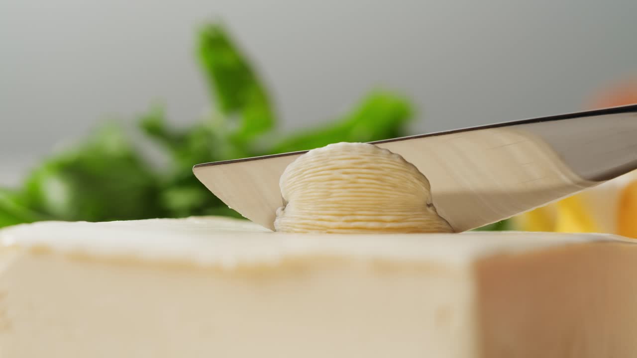 Young woman spreading nut butter onto toast in kitchen, closeup. High quality 4k footage