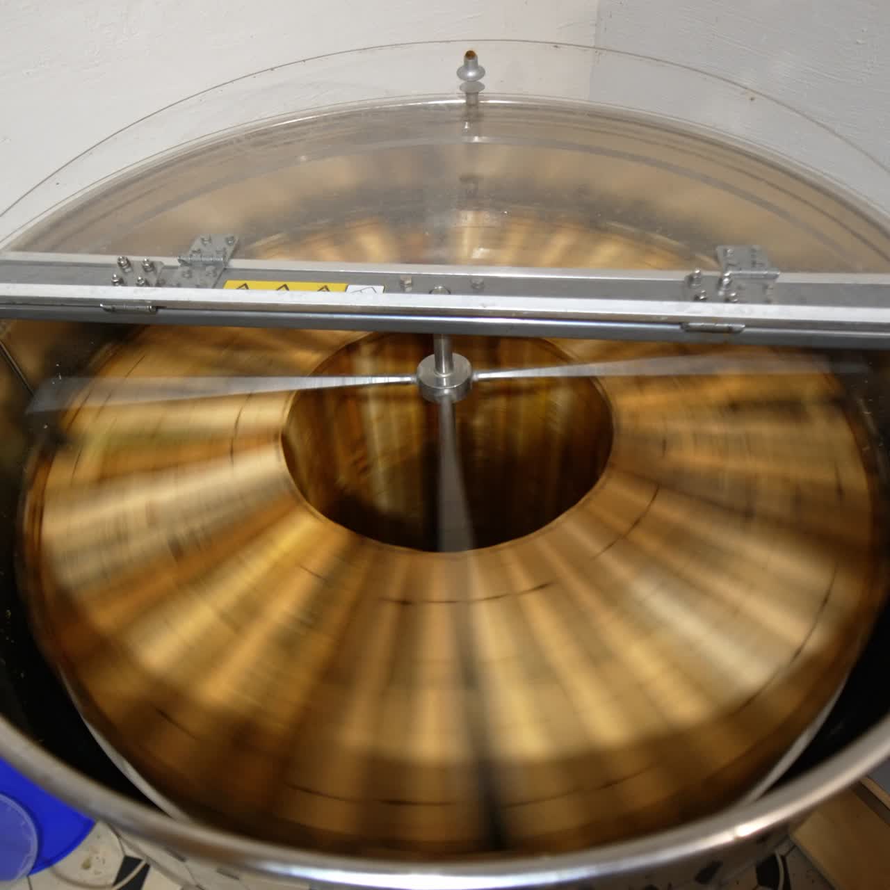 Electric device rotating frames with honey. Machine with opened lid working in the apiary. View from top