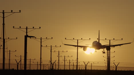 Airplane-Passing-Overhead-To-Land-Passing-Through-Setting-Sun