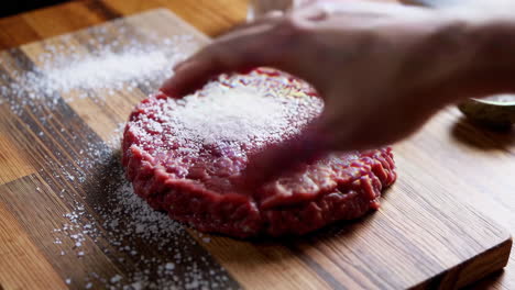 preparing a raw hamburger pattie
