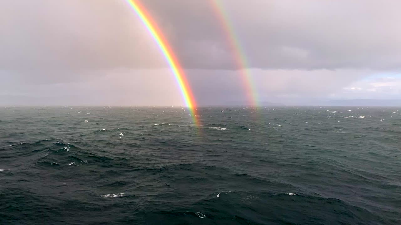 Awesome and lovely, rare double rainbow from cruise ship in North Sea off coast of Norway at Arctic Circle near Berents Sea with white water waves, HD 1080p