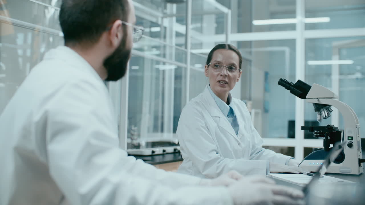 Scienziata che parla con un tecnico di laboratorio in un centro di ricerca