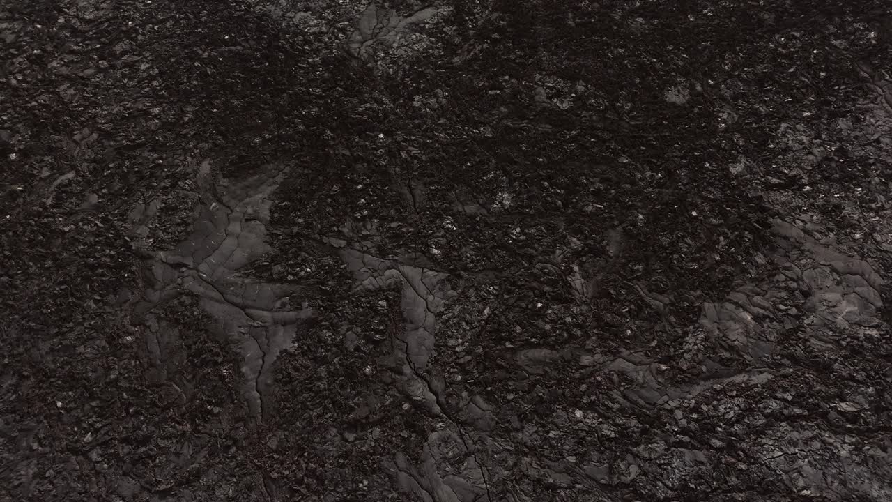 tierra de roca ígnea negra de lava sólida fría con hollín, ceniza y piedra