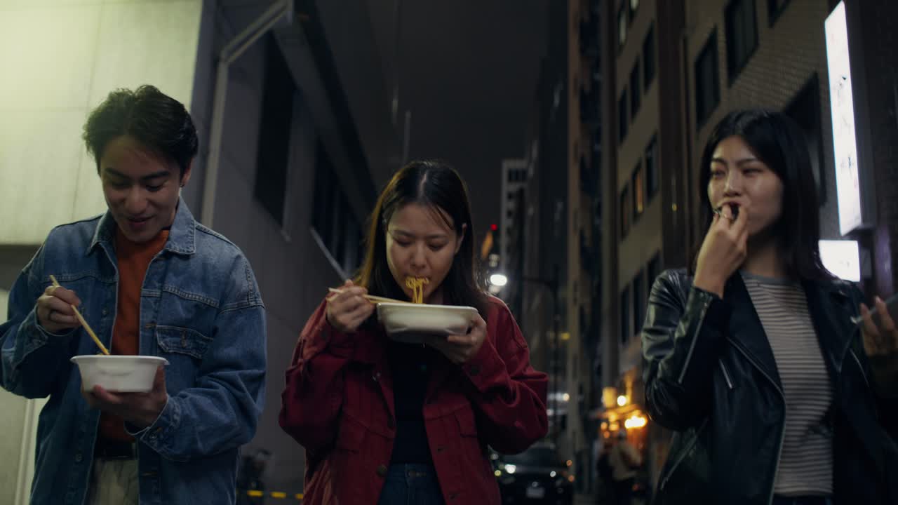 Friends Eating Dinner in Japanese City Street at Night