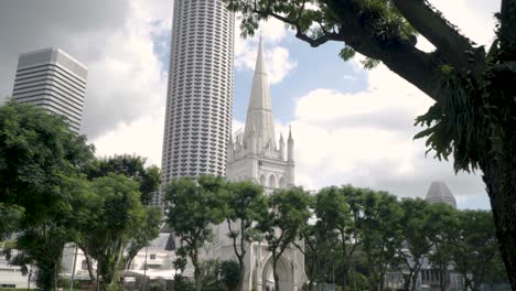 vista de la catedral de st andrews en singapur con la torre de la ciudad de raffles en el fondo - inclinación hacia arriba