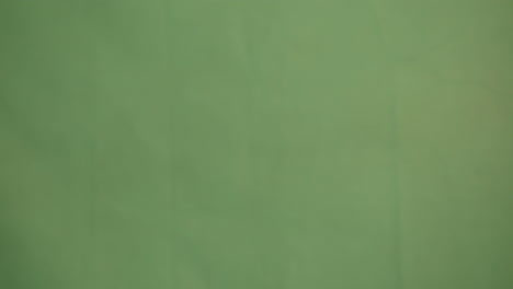 una mano femenina ligera chasqueando y sosteniendo en la pantalla verde