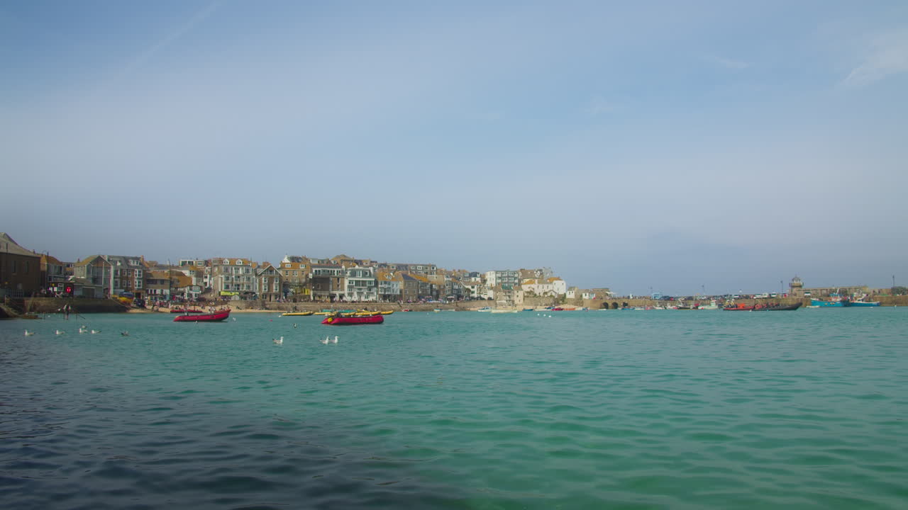 영국 콘월에 있는 보트와 해안 구조물이 있는 세인트 아이브 항구 해변의 전망