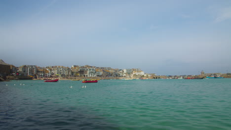 vista de la playa del puerto de st ives con barcos y estructuras costeras en cornualles, reino unido