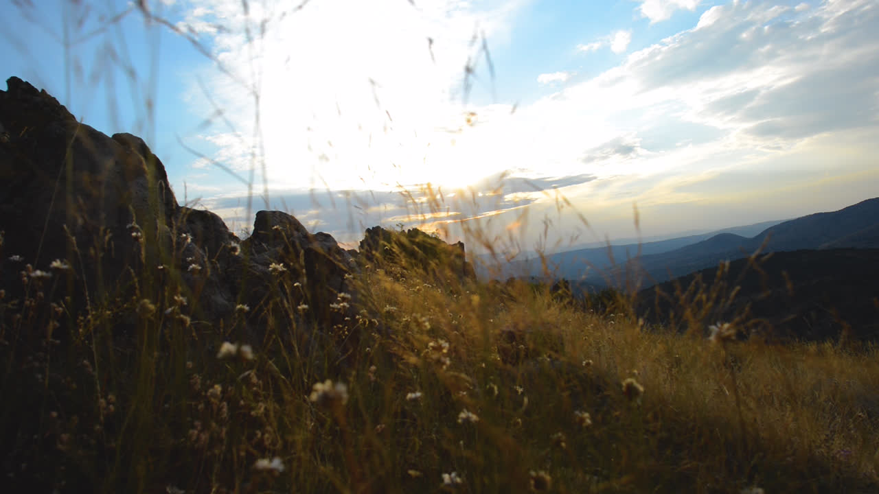 잔디를 통해 바람을 rustling, 바위와 하늘의 전망