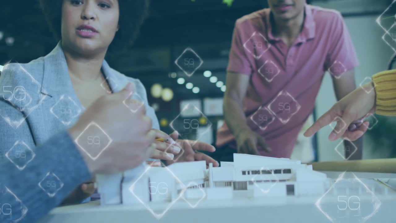 Animation of 5g and 6g text banners against diverse colleagues discussing over a model at office