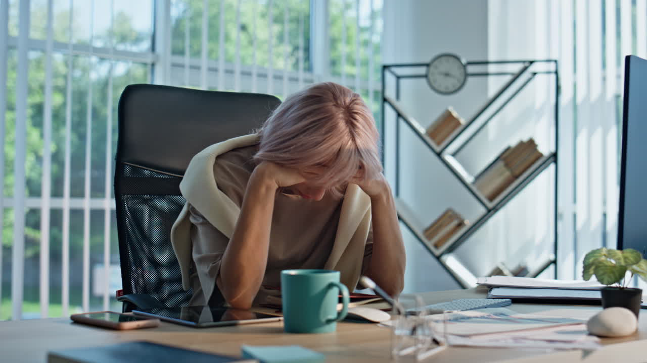 Primo piano di un regista stanco che chiude il quaderno e si prende una pausa in uno spazio di coworking