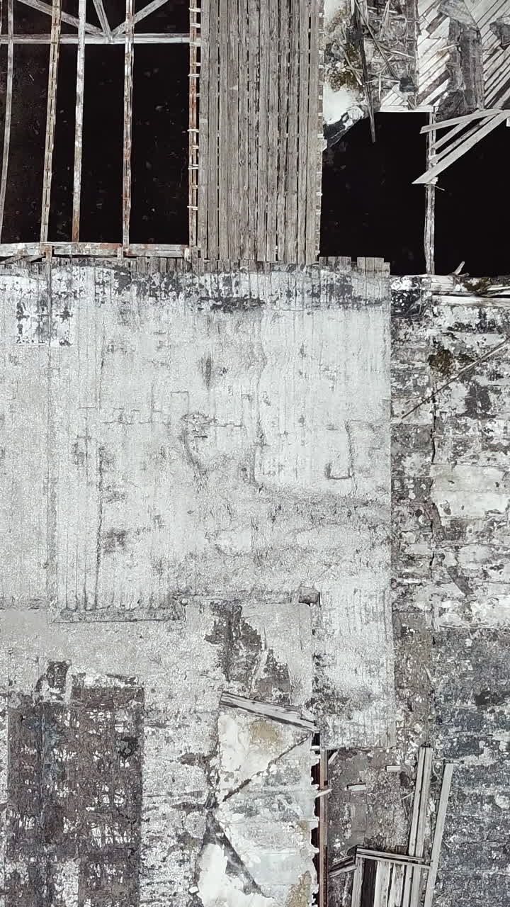Ruined roof of an old abandoned factory. Aerial view. Vertical video