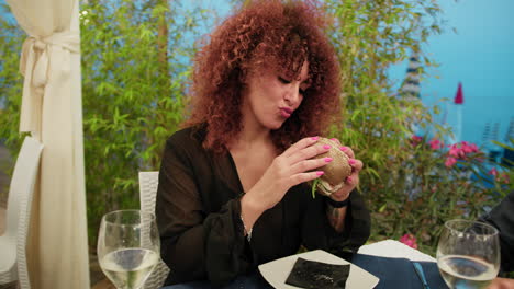 woman enjoying the dinner at the resort with a gourmet fish burger