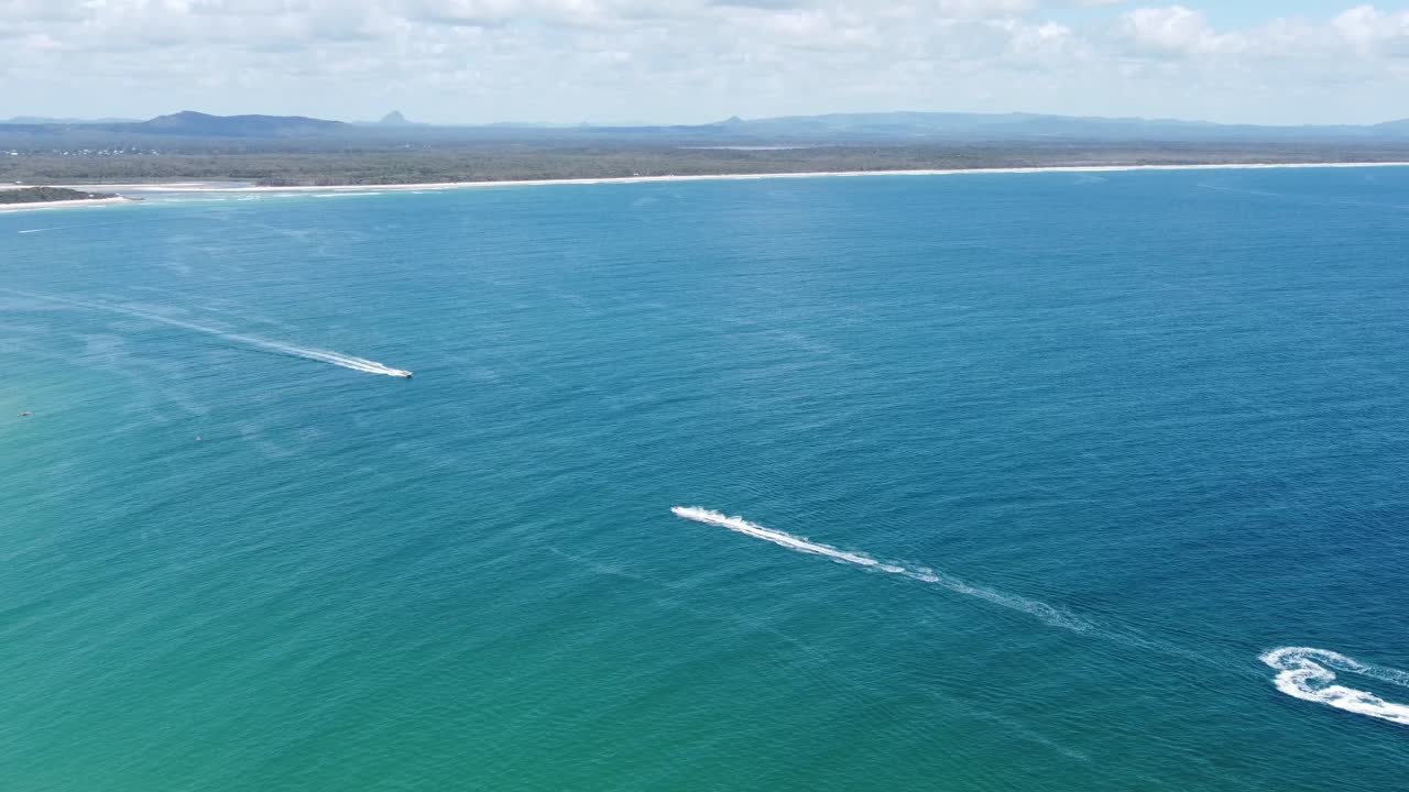 아래의 바다 제트 스키와 배경의 모래 해변 위로 후버링