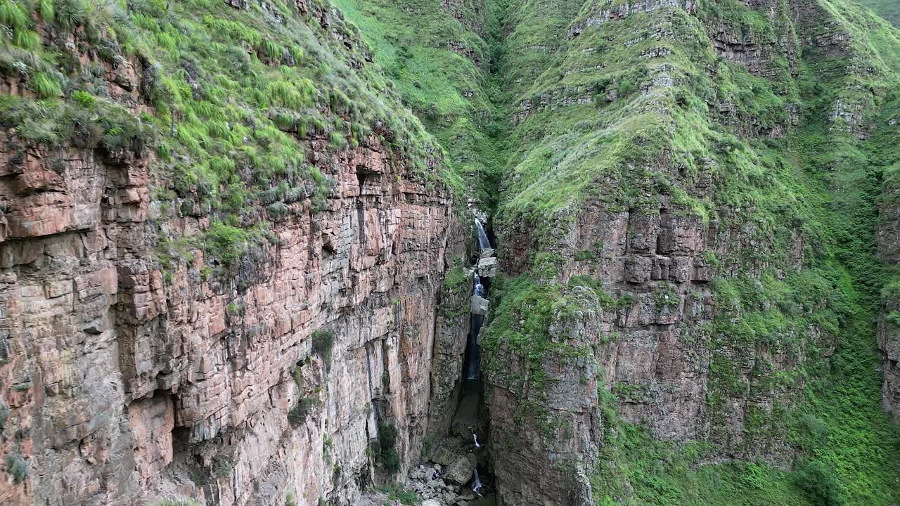 공중: 가파른 산 절벽이 깊은 협곡에 있는 폭포를 숨기고 있습니다.