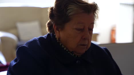 granny slices fruit while eating apple, gestures approval to another