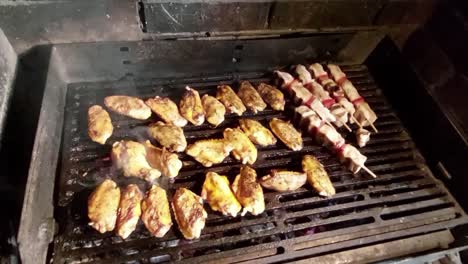 Alitas-De-Pollo-Y-Brochetas-A-La-Parrilla-De-Carbón-Asado-En-Malla-Caliente-Y-Saliendo-Humo