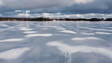 patches of snow on a frozen lake on a cloudy day