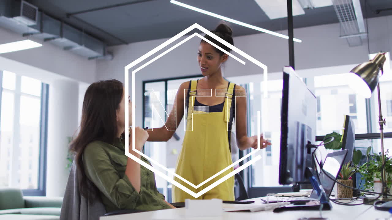 Two women discussing in office with NFT text animation overlay