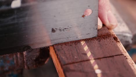 guitar artisan sawing slots for frets on guitar neck or fret board