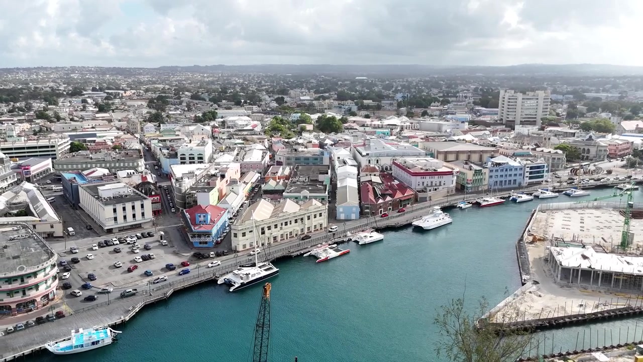 Panorama drone luas di atas area pelabuhan industri, dermaga komersial, dan pemandangan kota pusat kota di bawah langit berawan di wilayah ibu kota Bridgetown, Teluk Carlisle, Barbados