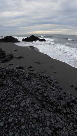 dark volcanic beach with waves