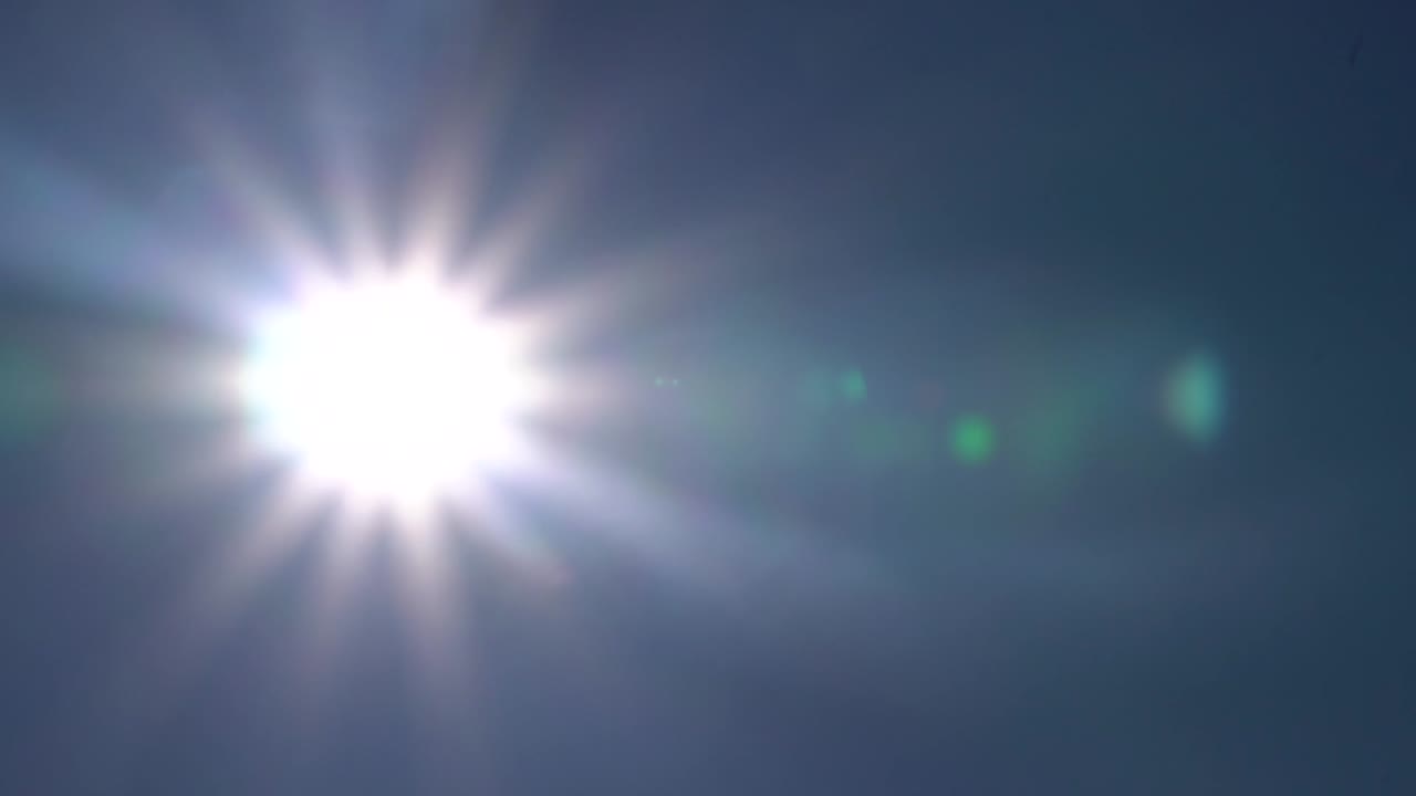 the sun shining in the blue sky thru the camera elements in 1080p 59.94p