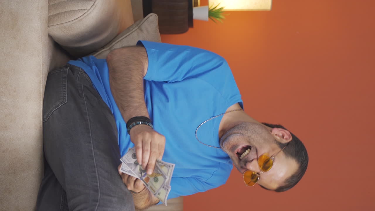 Video verticale di uomo che conta i soldi guardando la telecamera.