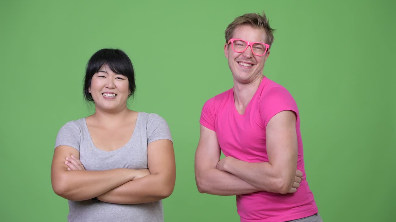 과체중 아시아 여성과 젊은 동성애자 남성이 팔을 고 있습니다.