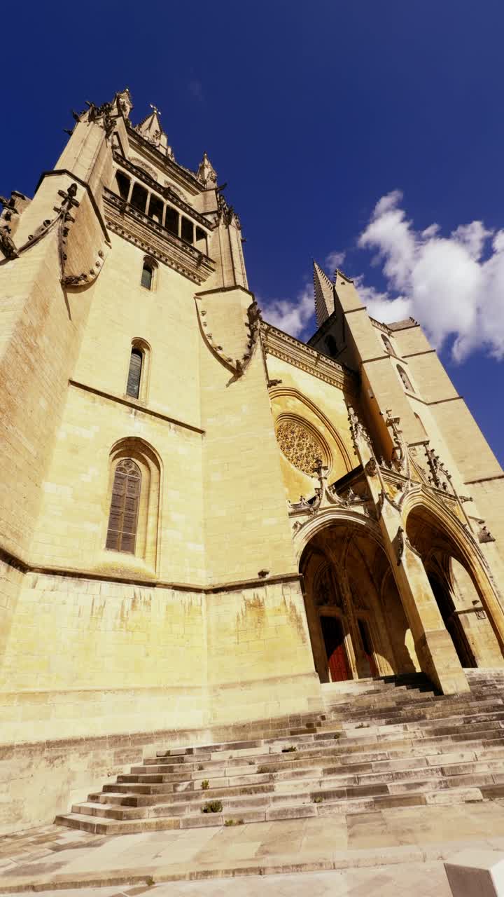 A majestic cathedral of Mende basks in sunlight under a vivid blue sky.