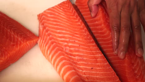 chef cutting the fresh meat fillet in half and separating from a skin for sushi