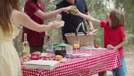 plano medio de la mesa de la familia caucásica durante un picnic en el bosque