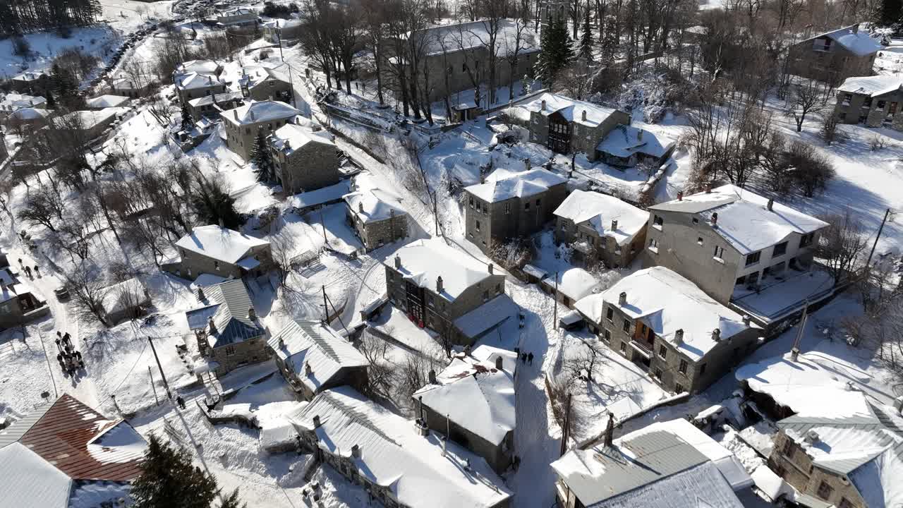 Tilt up of houses after heavy snowfall in the town of Nymfaion, Florina, Greece.