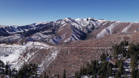 Drone-shot-pushing-overtop-of-a-mountain-road-with-a-mountain-in-distance