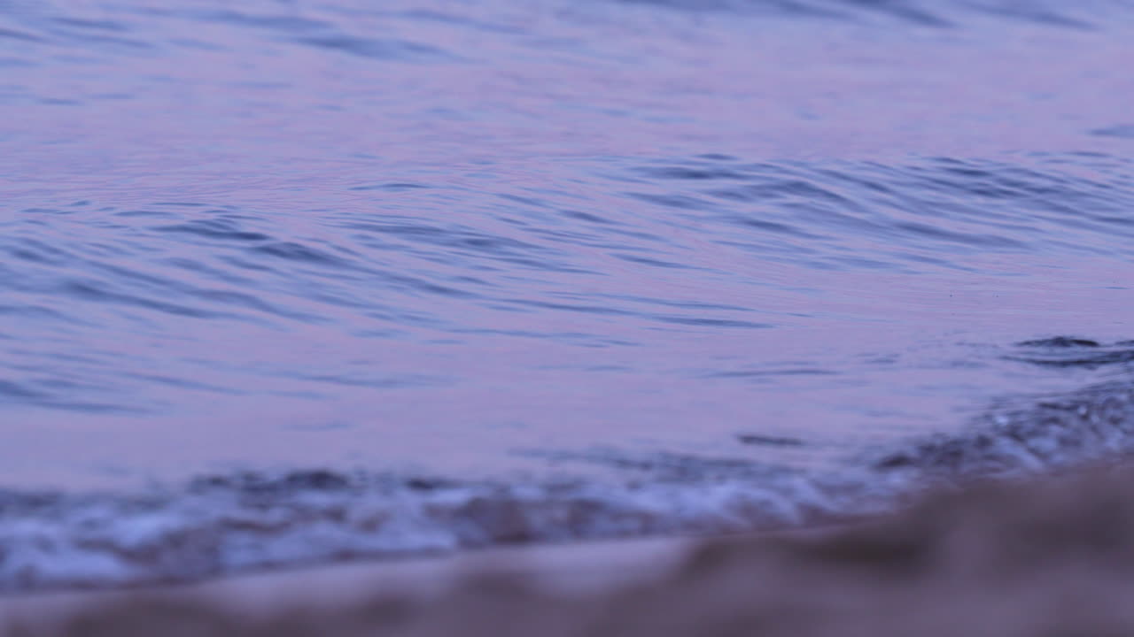 Gentle wave ripples on a calm blue sea surface under soft daylight