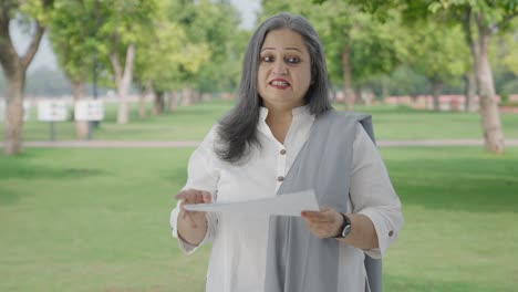 Happy-Old-Indian-woman-discussing-reports-in-park