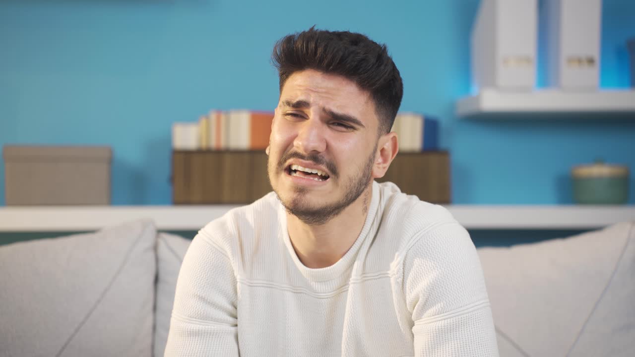 Giovane uomo che piange a casa