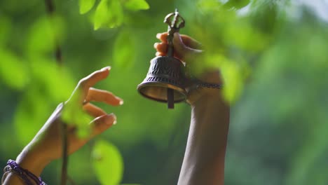 Cerca-De-La-Mano-De-Una-Mujer-Sosteniendo-Una-Campana-En-El-Parque-Salto-Encantado-Ubicado-En-Misiones,-Argentina.