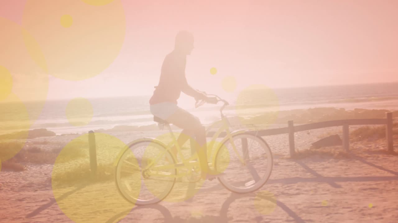 해변에서 자전거를 타는 백인 여성에 대한 빛의 노란색 반점