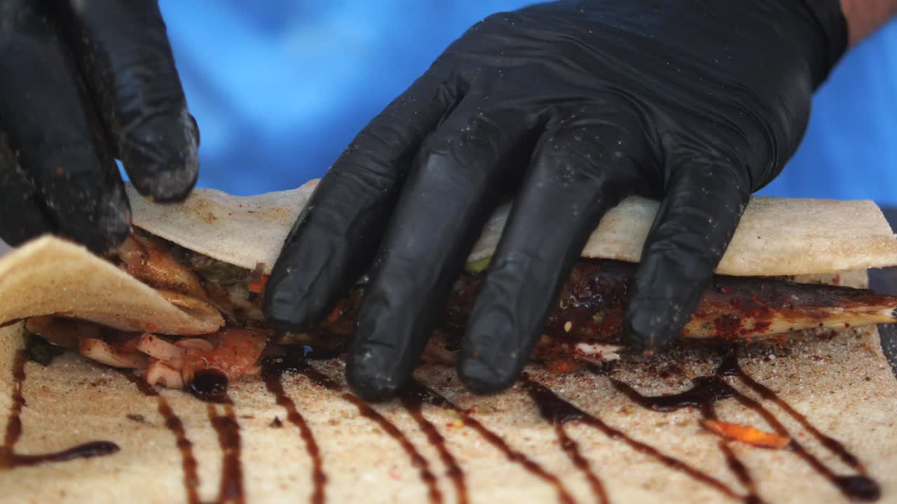 chef preparando un envoltorio de pescado con salsa y verduras
