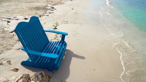 Blue-beach-chair-in-the-sand-by-the-ocean